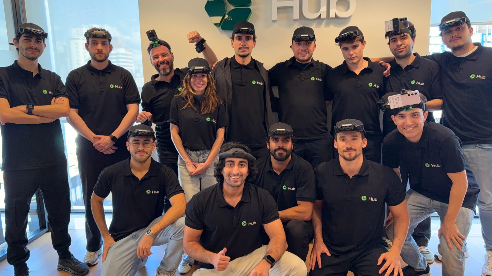 The Hub team in Hub polos in front of the Hub logo, most wearing head-mounted capture rigs